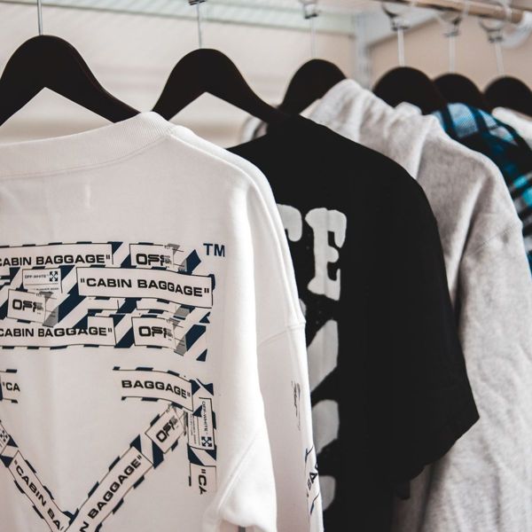 Graphic print t-shirts in white and black hanging on a clothing rail