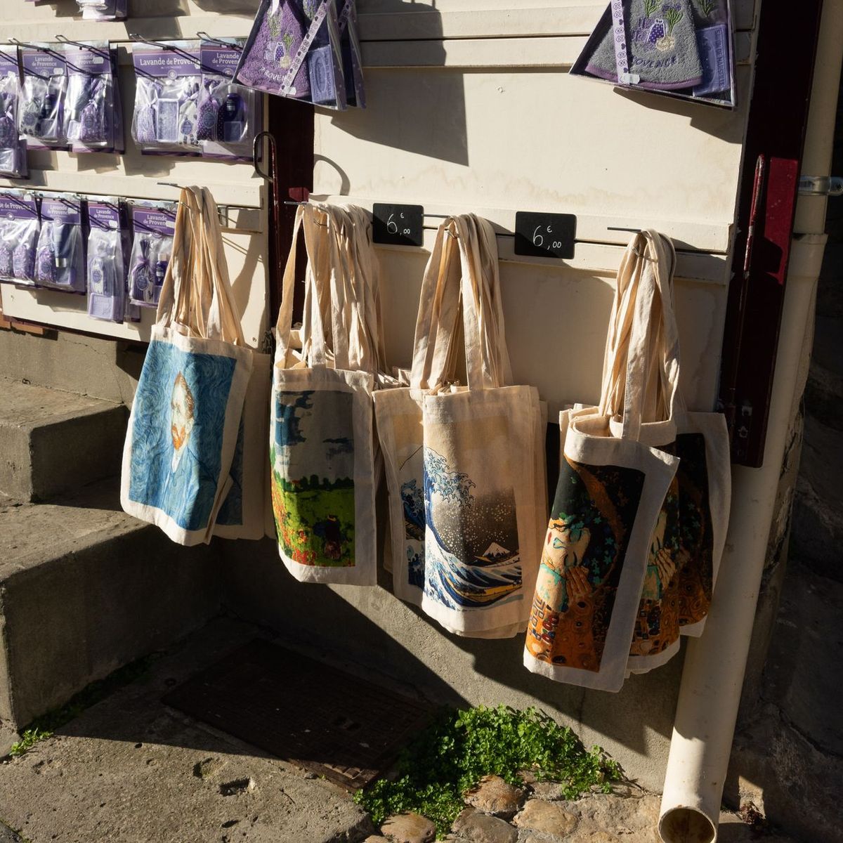 Printed canvas tote bags hanging outside a market stall
